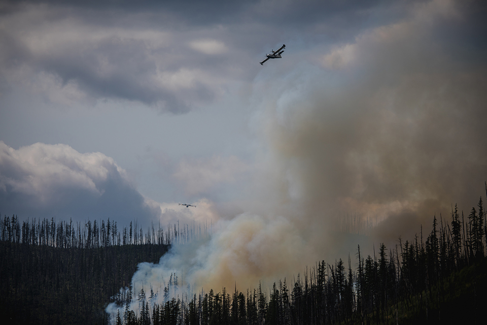CL-215 Scooper plane fly over the Howe Ridge Fire dropping water.