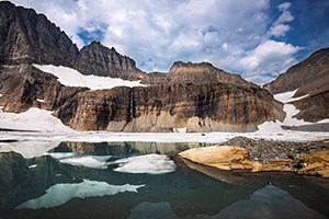 Snow/ice patches on ridge above teal lake