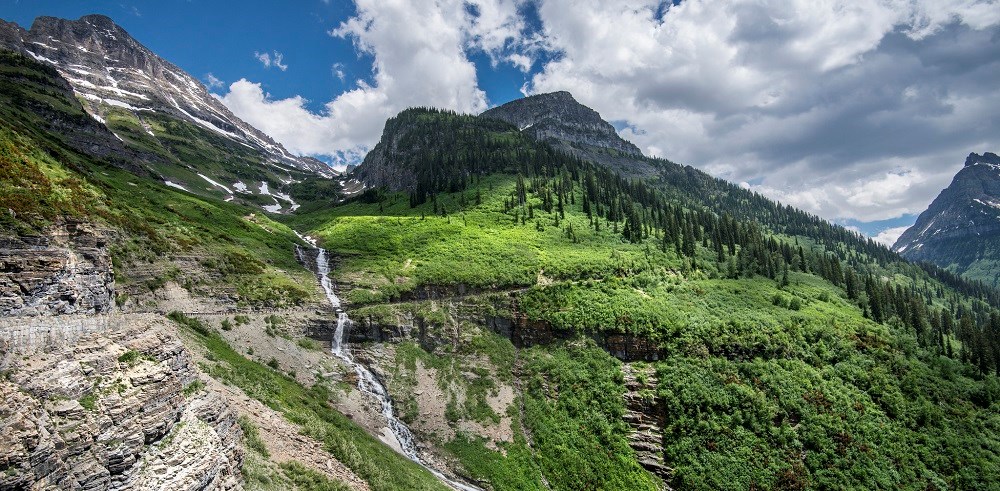 mountain road climbing past waterfall