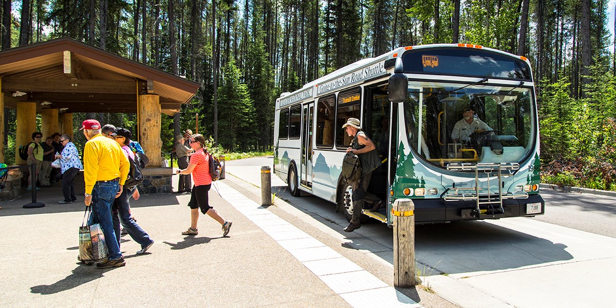 Visitors boarding the shuttle at the Apgar Visitor Center