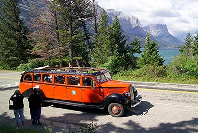 Red Bus stopped on the side of the road by St. Mary Lake