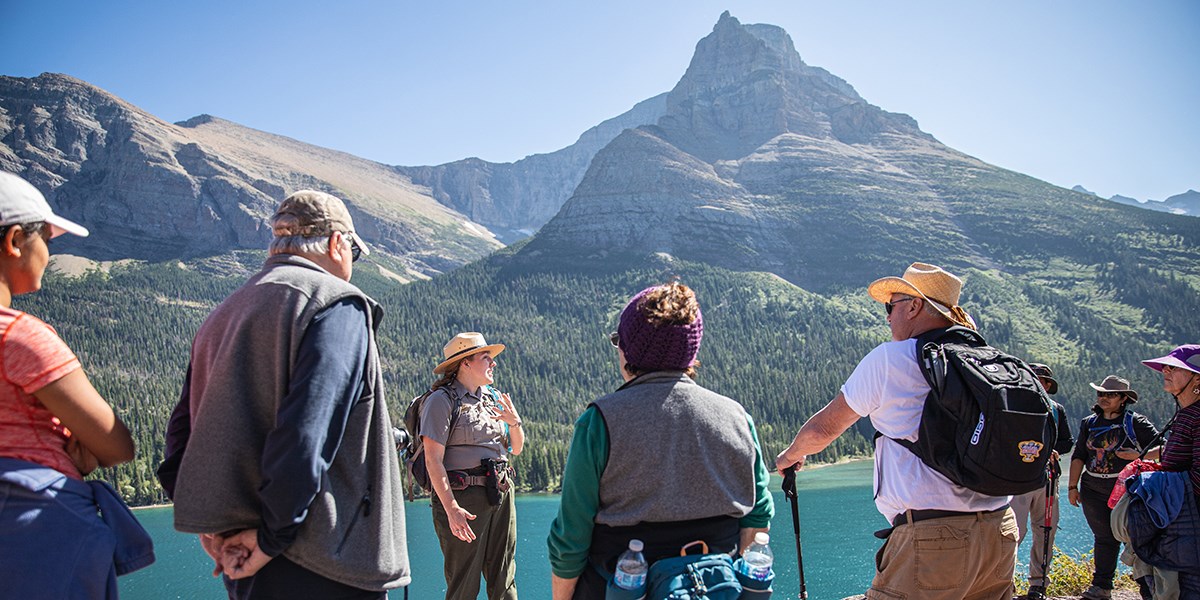 Ranger and visitors stopped on a hike overlooking St. Mary Lake.