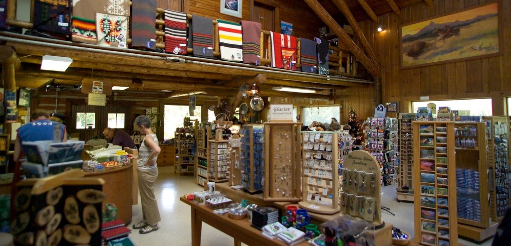 Wool blankets hang above shopper in large wooden building filled with merchandise racks