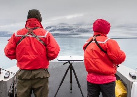 Two researchers surveying in the fog.