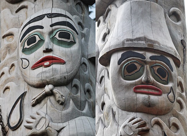 two detailed faces, each with a tear leaving its eye, are carved into a totem pole