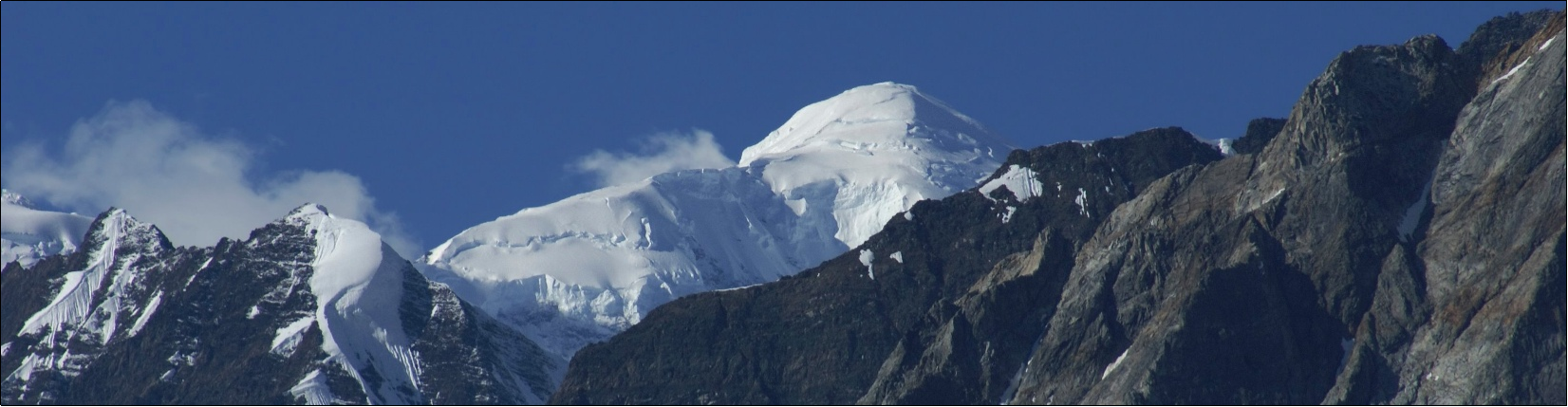 Snowy peak with drifts standing above surrounding mountains