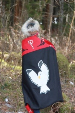 Tlingit child releasing eagle feathers at groundbreaking ceremony of the Huna Tribal House in Glacier Bay