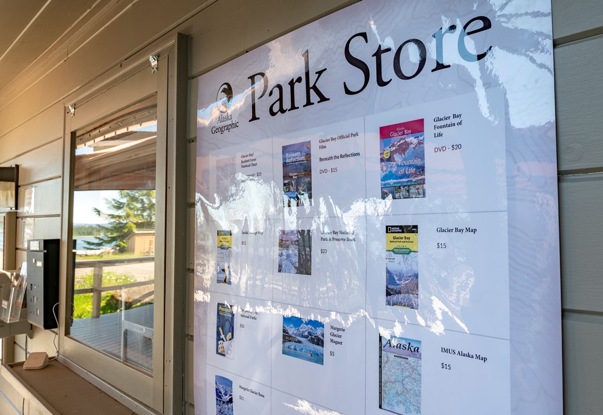 A laminated sign reading "Park Store" and displaying Alaska Geographic items for sale, next to the VIS window.