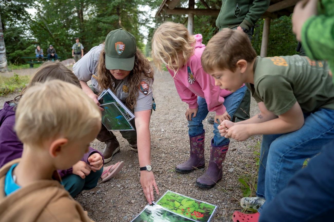 Ranger with kids A Park ranger and a group of kids circled around images of berries.