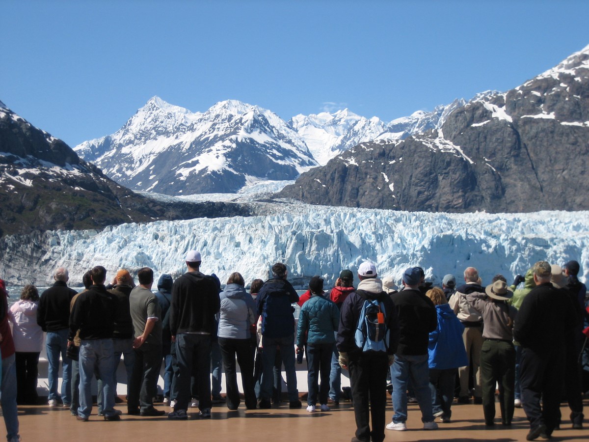 People standing on the deck of a cruise ship looking at a glacier.