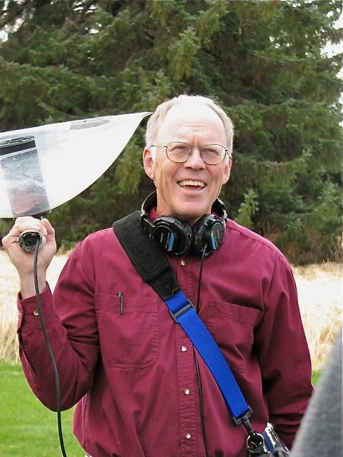 Richard Nelson holds a parabolic microphone on his shoulder.