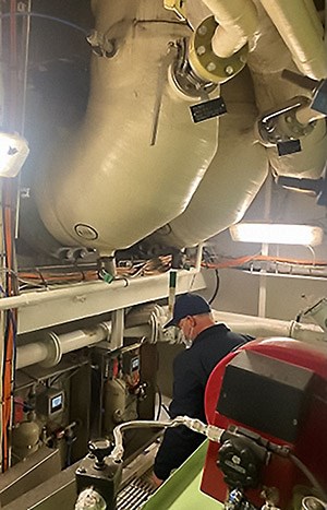 Inspector examining valve Inspector examining valve inside equipment room on a cruise ship