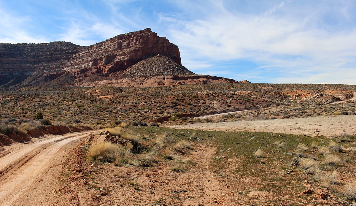 Hole-in-the-Rock Road within park Dusty unpaved road curves past mesa