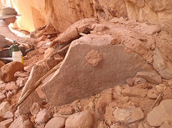 Park ranger uses scientific equipment on ancient rock and mortar structure