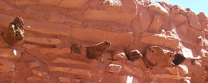 Close up of ancient rock wall. All orange sandstone. Wooden beams stick out close to the top. Close up of ancient rock wall. All orange sandstone. Wooden beams stick out close to the top.