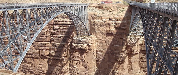 Two almost identical steel-arch bridges span the canyon. A parking area is on the other side. Two almost identical steel-arch bridges span the canyon. A parking area is on the other side.