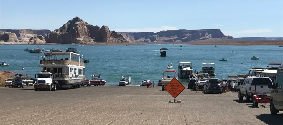 many boats of various sizes on a launch ramp and in the water many boats of various sizes on a launch ramp and in the water