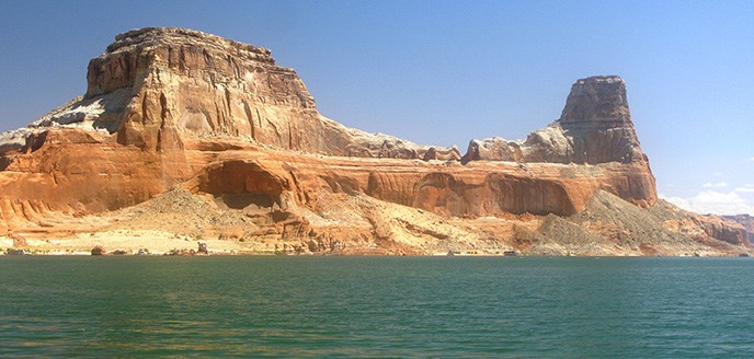 A curvy butte rises from the waters of Lake Powell. A curvy butte rises from the waters of Lake Powell.