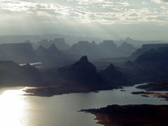 Hazy still morning aerial view of Lake Powell with cliffs rising from the water.