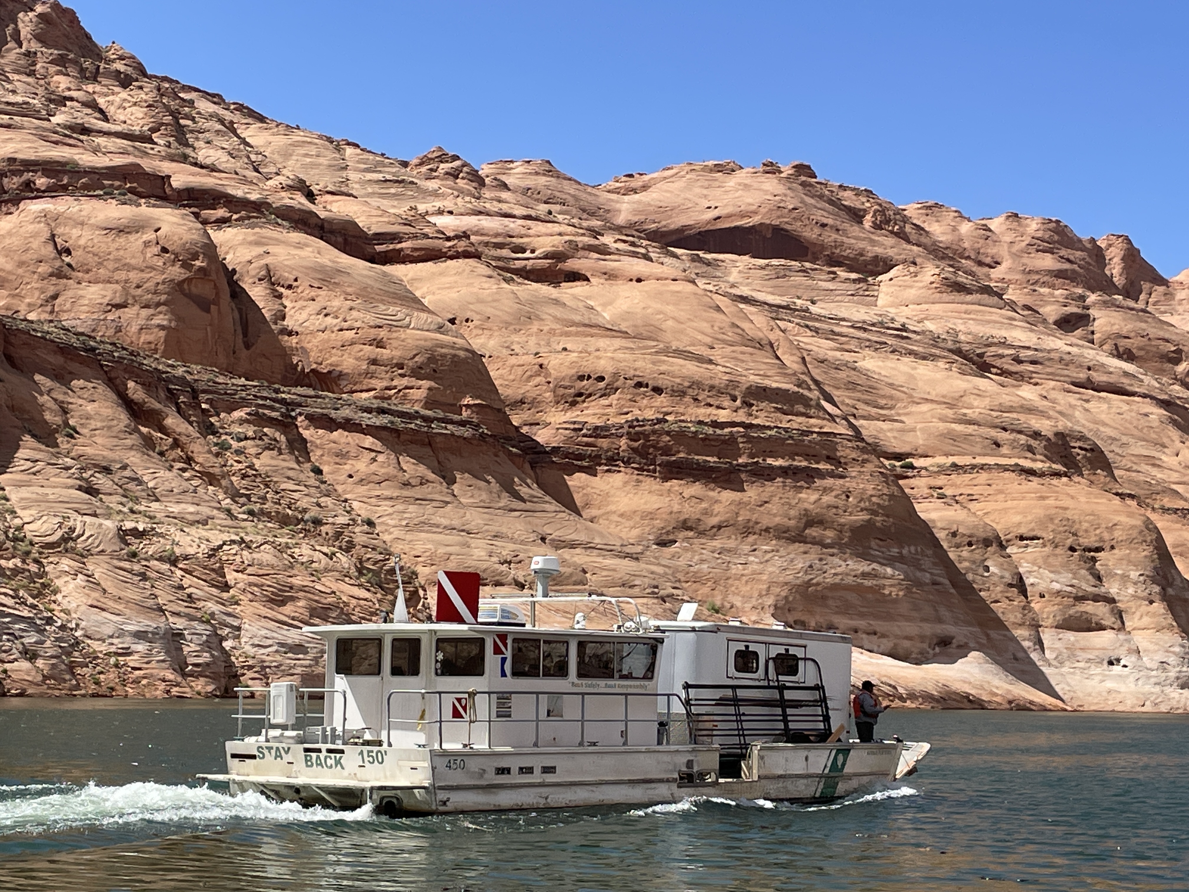 Horses on Board! A Large National Park Service vessel with a horse trailer boats a narrow canyon.