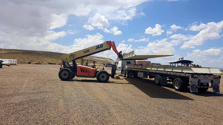 Aramark unloading gangway sections of new Stateline courtesy docks. Extending forklift lifts large sheets of metal onto a truck.