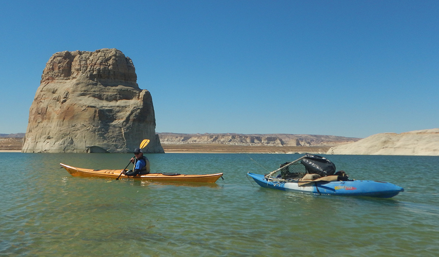 Kayaker tows a riderless kayak filled with trash