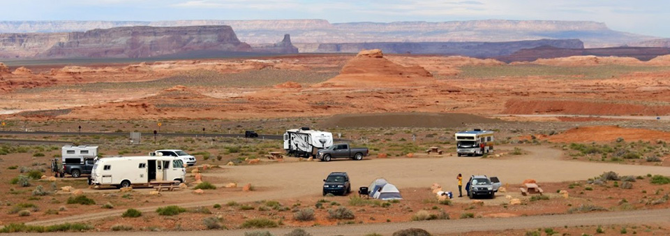 gravel lot with scattered RVs and people