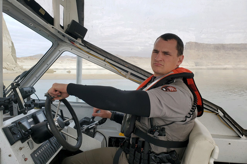 Park Ranger in boat wearing lifejacket and police gear