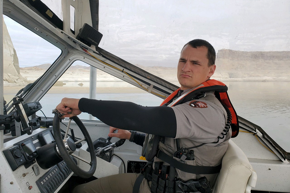 Glen Canyon Ranger Zachary Stuenkel Park Ranger in boat wearing lifejacket and police gear