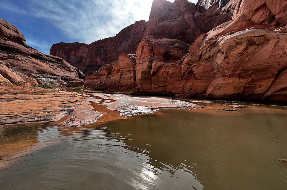 Rainbow Bridge Access Impacted by Storm Muddy water at rocky shoreline