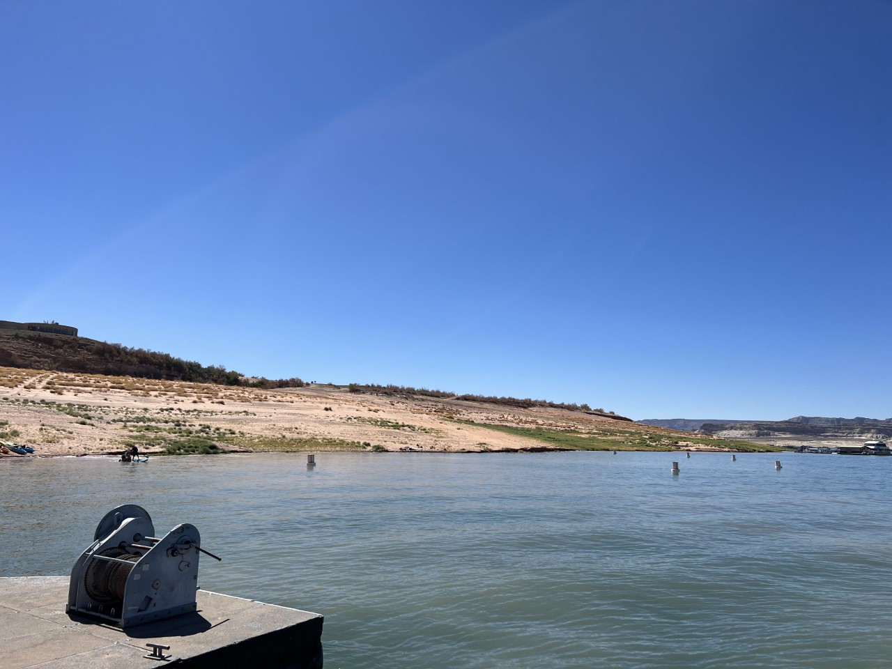 white buoys on the water surround a sandy beach