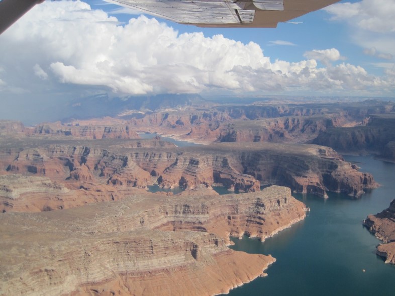 Aerial view of canyon landscape. Small plane wing in view