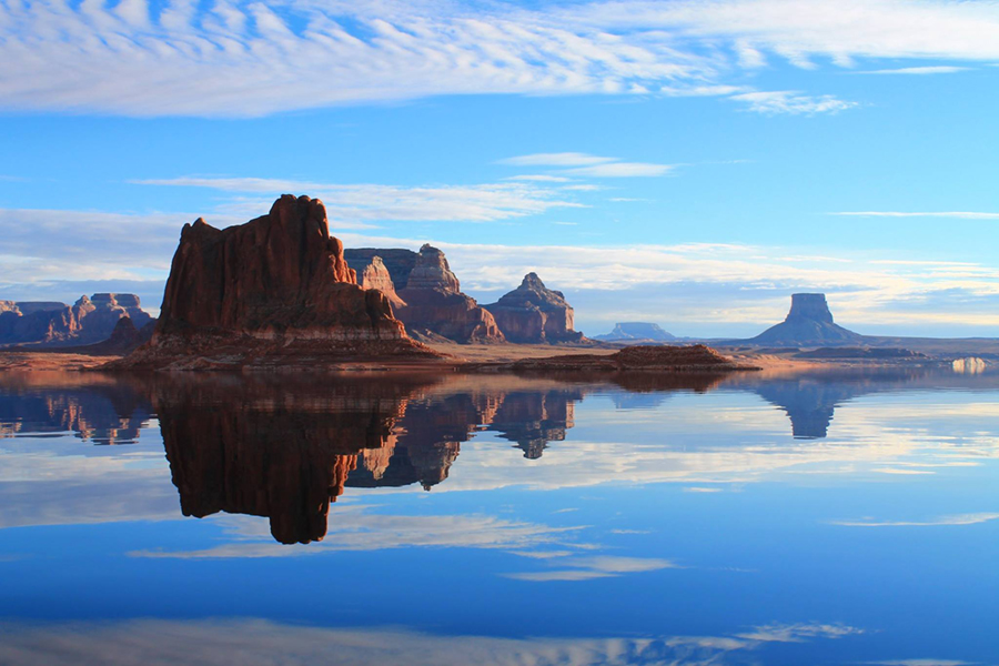 sandstone cliffs reflected on still water