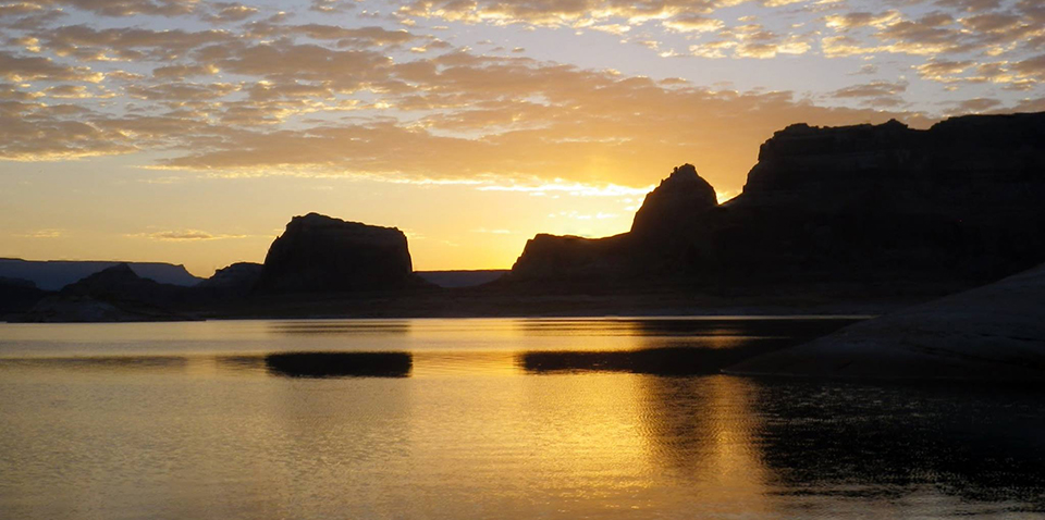 sunset on lake with silhouette of rocks