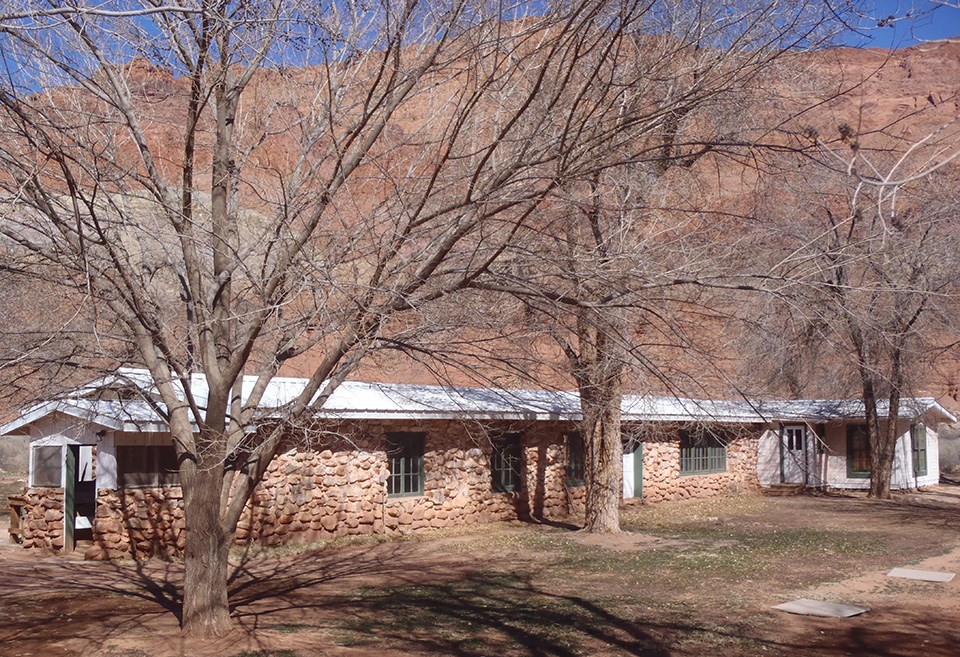 Historic Weaver Ranch House at Lees Ferry stone house with white roof. Winter trees.