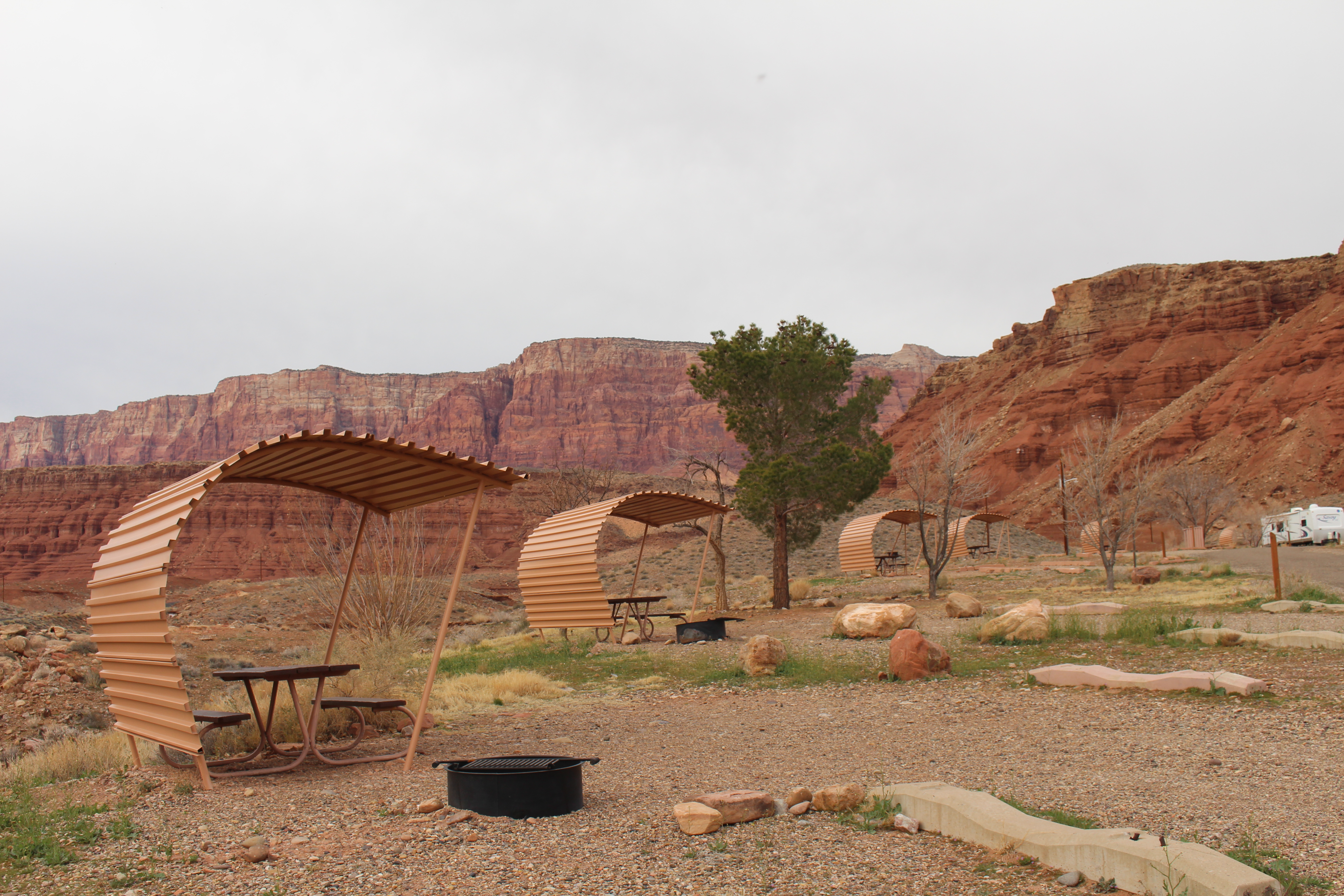 Rows of campsites with shade shelters and campfire rings