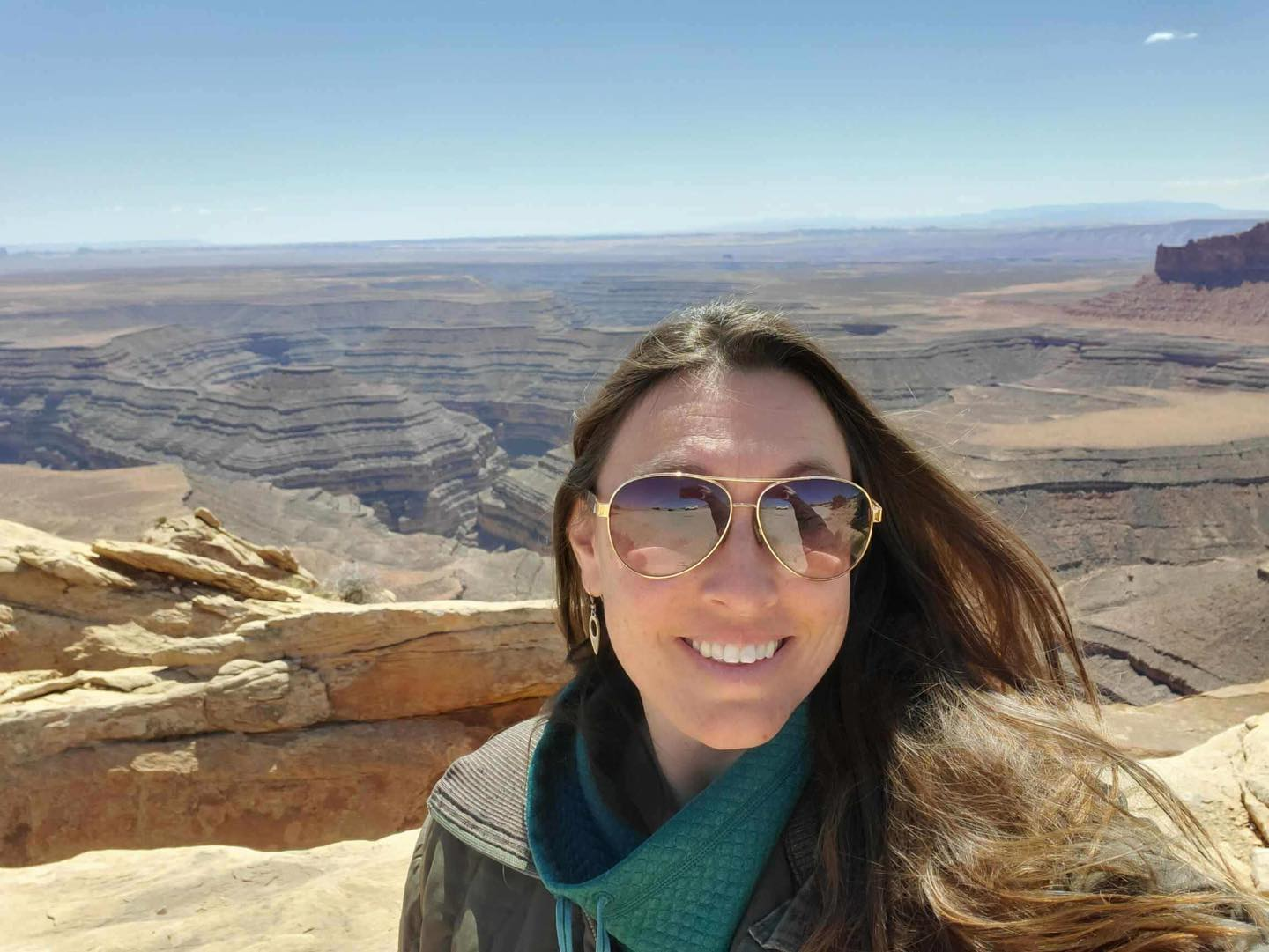 Nichelle Rich Person with long brown hair and sunglasses in front of curvy canyons