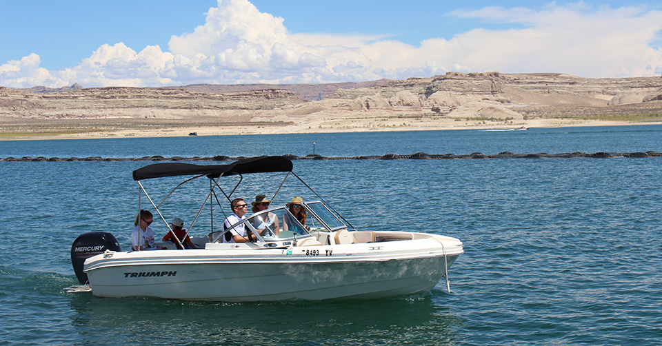 family sits in motorboat on lake