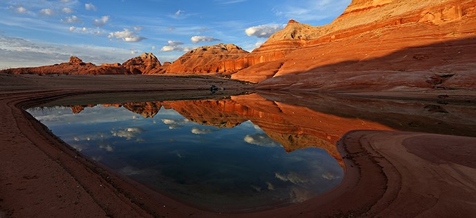 Scenic view of dark sandstone and water. Scenic view of dark sandstone and water.