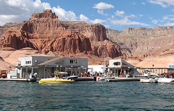 Boats pull up to dock store below incredible sandstone cliffs