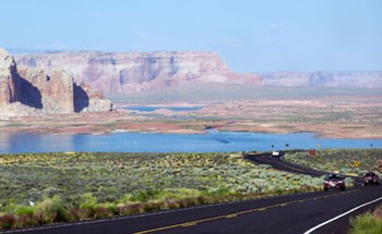 sandstone cliffs, lake, road with cars