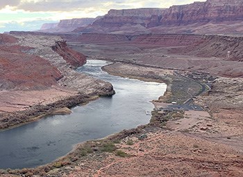 View from top of cliff down at launch ramp, river, and sandstone cliffs