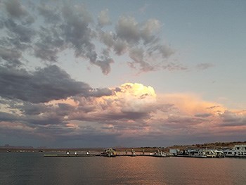 lake with marina, billowing clouds above