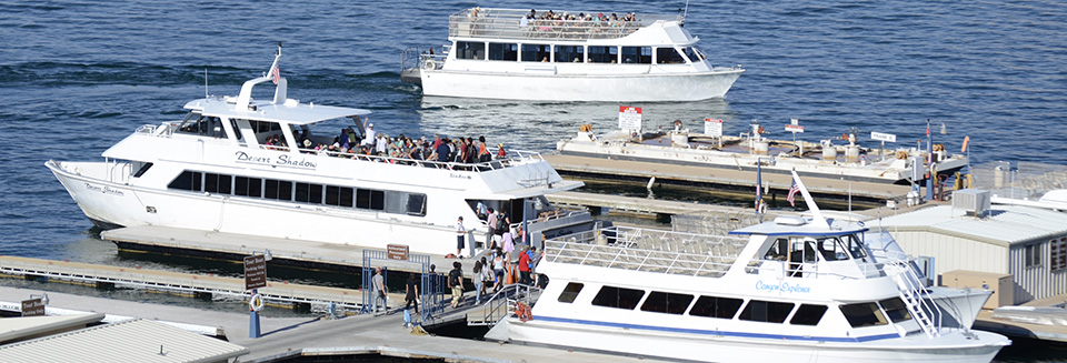 Three large white boats full of people at a dock. One boat is departing. Three large white boats full of people at a dock. One boat is departing.