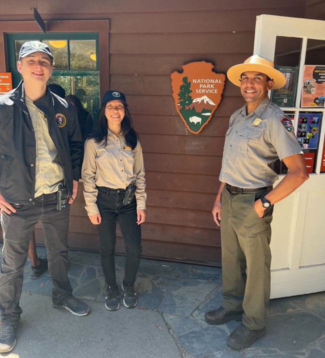 Interns pose at in front of an NPS sign at Muir Woods with Park Ranger