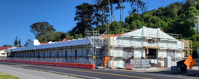 Building 643 with scaffolding and white plastic wrap covering building.