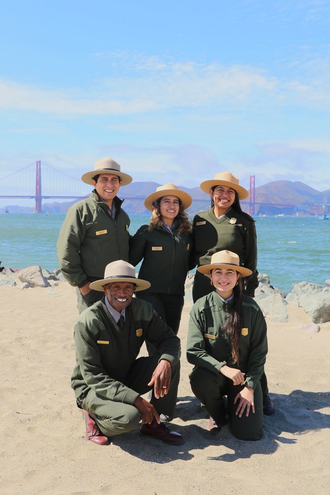 A group photo of the GGNRA Education Team posing in front of the Bay with the Golden Gate Bridge in the background.