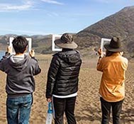 People look through frames at the landscape