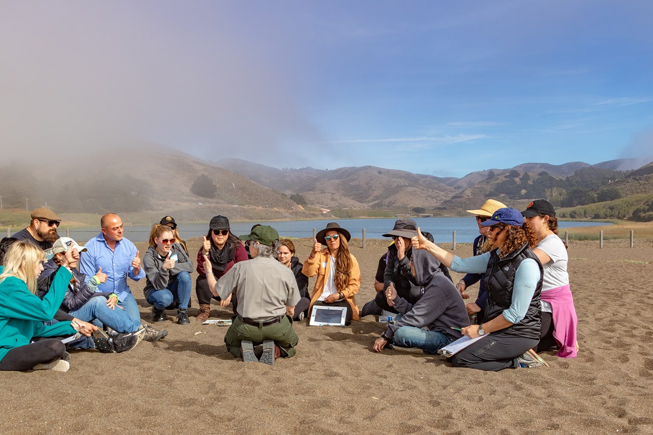 Teacher credential candidate class from San Francisco State University sitting on Rodeo Beach in the Marin Headlands