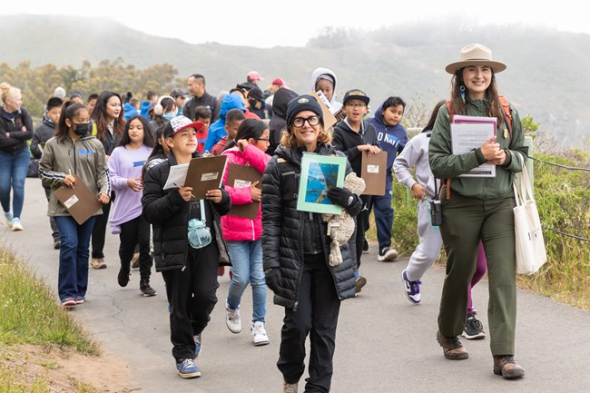 NPS Ranger Socorro, Volunteer Sarah, and students walk on the Point Bonita trail.